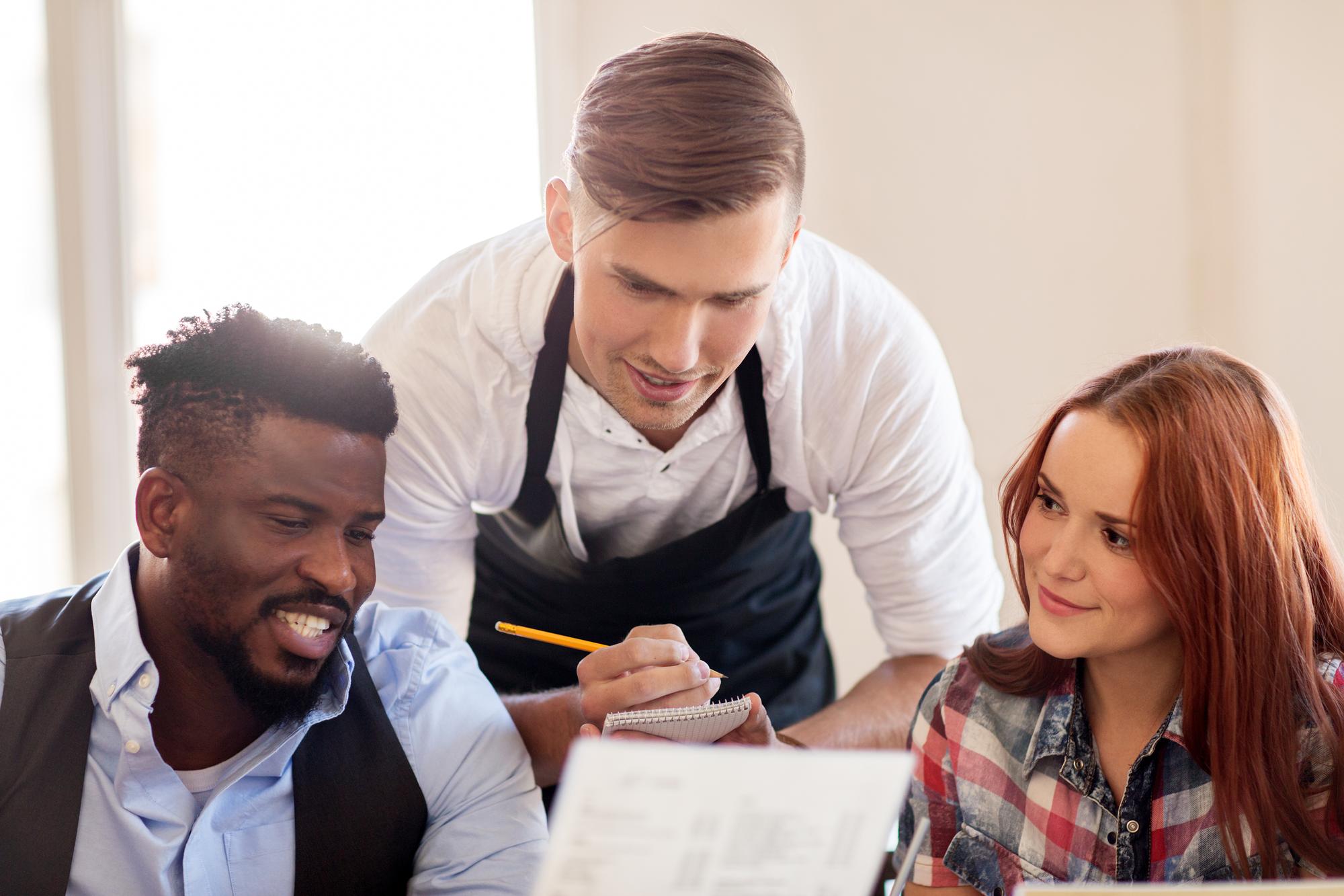 Chef consulting with hosts over menu notes